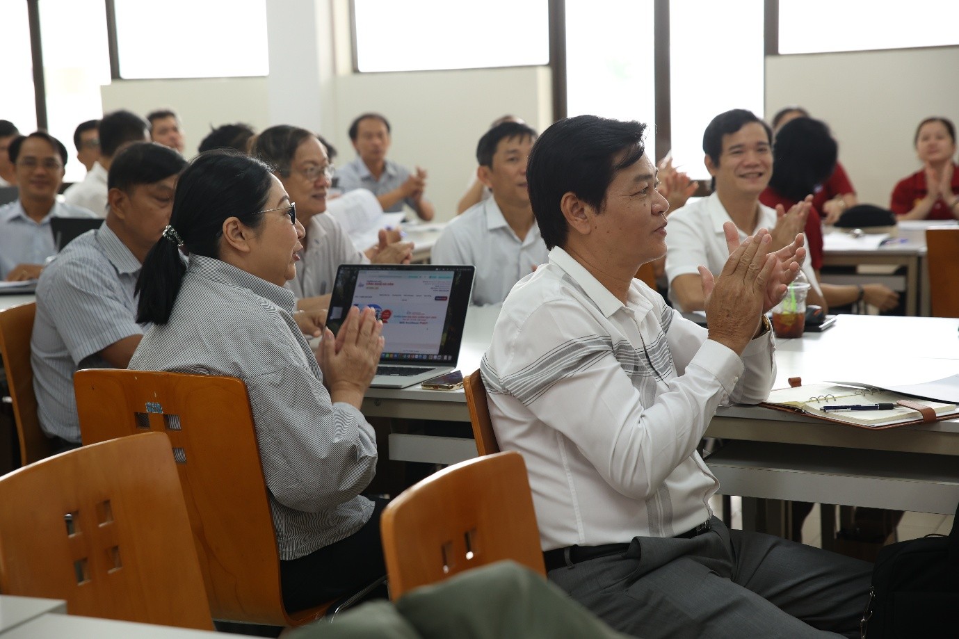 A group of people clapping in a classroomAI-generated content may be incorrect.