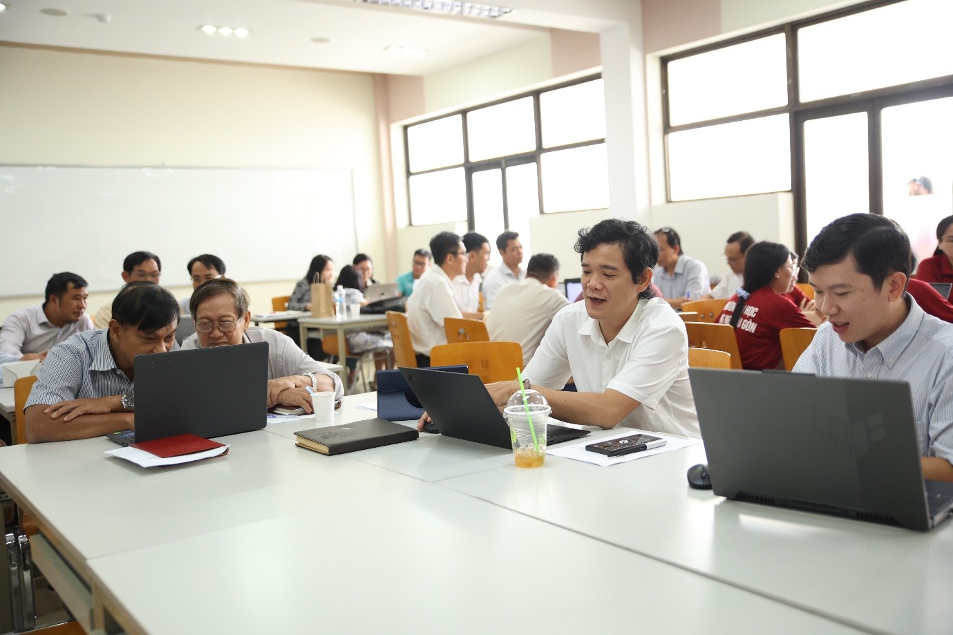 A group of people sitting at a table with laptopsAI-generated content may be incorrect.
