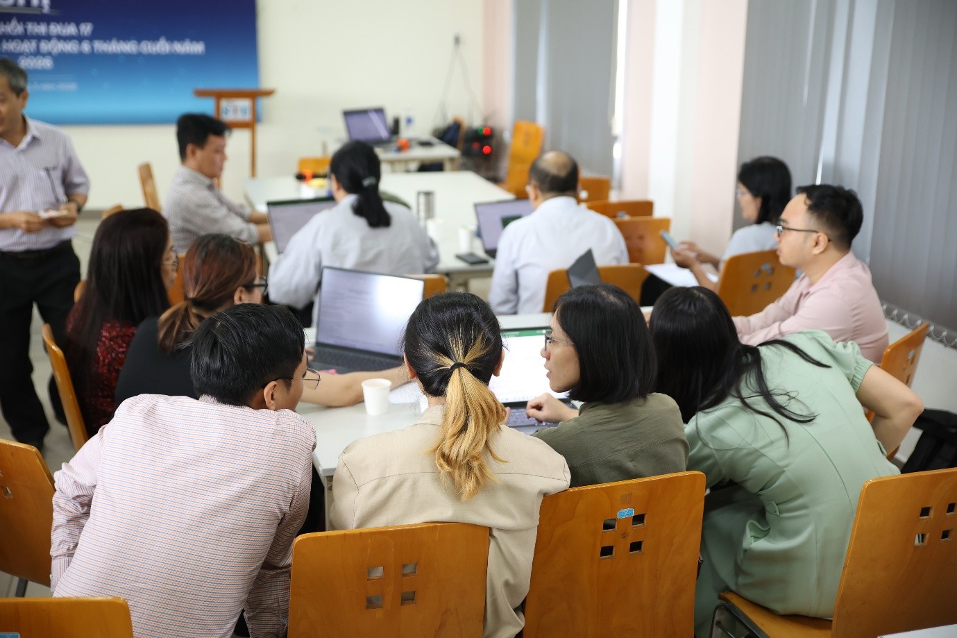A group of people sitting in a room with laptopsAI-generated content may be incorrect.